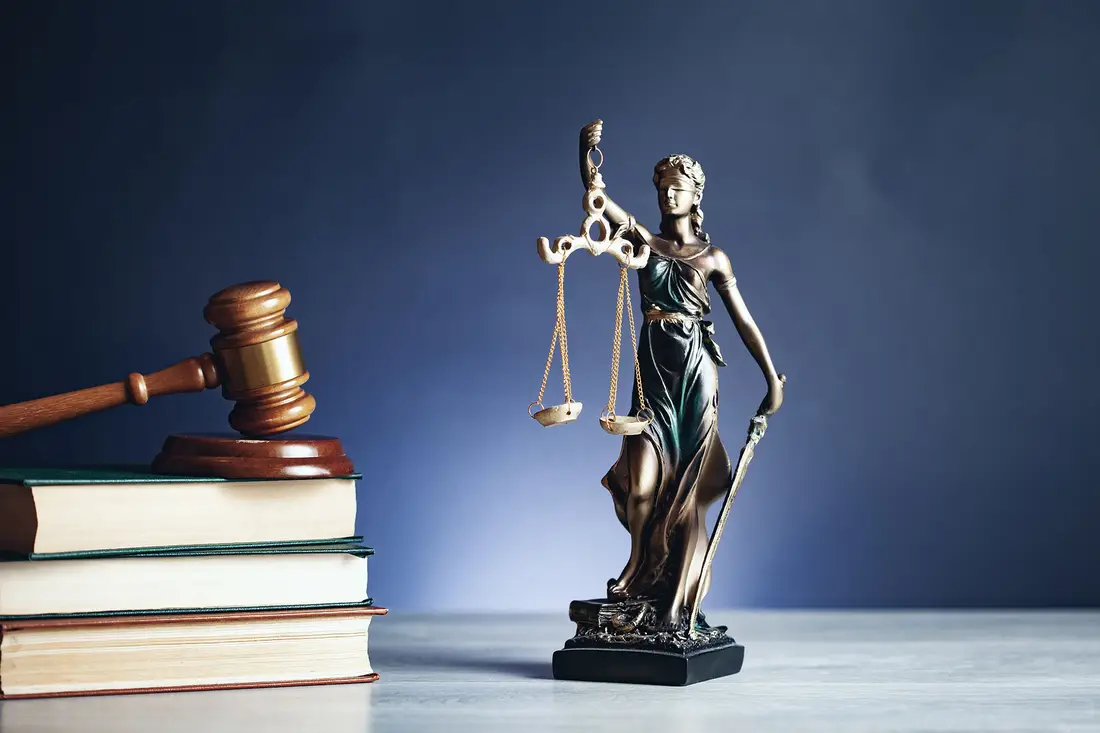 Estátua da justiça e martelo sobre livros